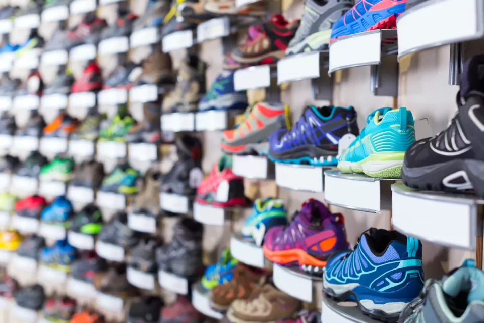 Wall of colorful sneakers for sale at a shoe store.